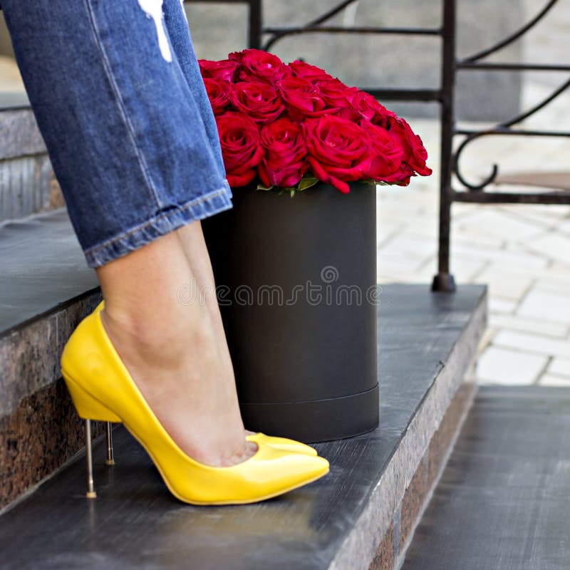 The bouquet of red roses and female legs stock images The bouquet of red roses and female legs stock images
