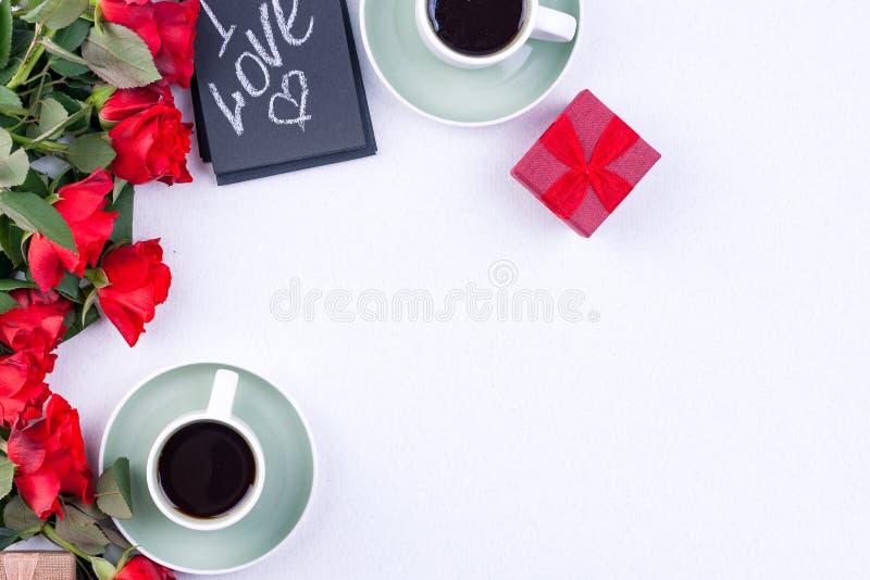 A bouquet of red roses and fresh aromatic tea for a romantic breakfast. Words of love on a note and a gift with flowers. Valentine stock photos A bouquet of red roses and fresh aromatic tea for a romantic breakfast. Words of love on a note and a gift with flowers. Valentine stock photos