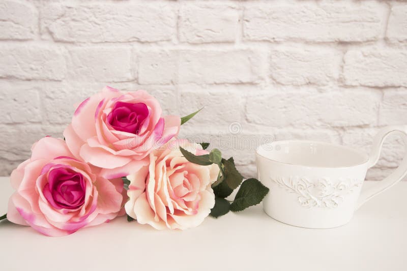 Bouquet of roses on a white desk, A large cup of coffee in front angel, Romantic floral frame background, Floral Styled Wall Mock royalty free stock photo Bouquet of roses on a white desk, A large cup of coffee in front angel, Romantic floral frame background, Floral Styled Wall Mock royalty free stock photo