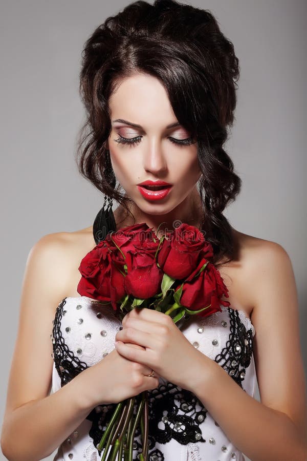 Bouquet sentant de jeune beauté des roses rouges. Plaisir et harmonie images libres de droits Bouquet sentant de jeune beauté des roses rouges. Plaisir et harmonie images libres de droits