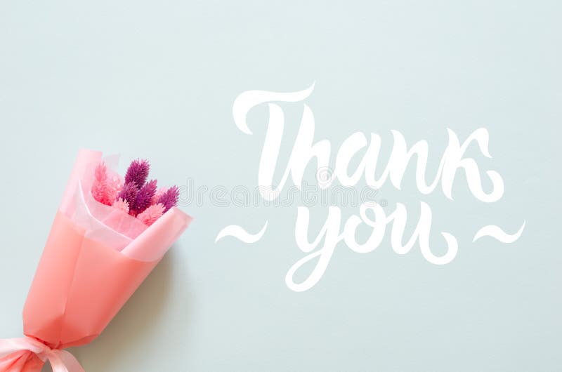 Bouquet of stabilized flowers and thank you lettering on blue background