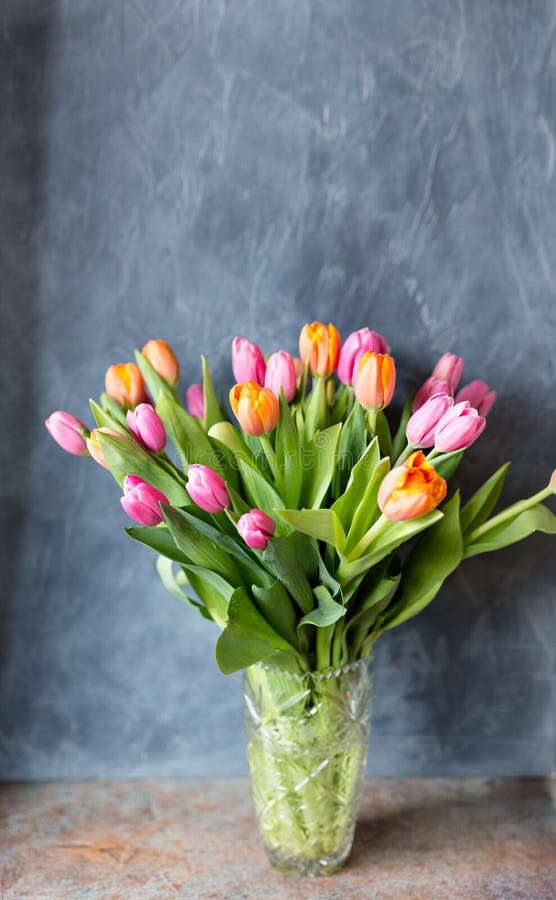 Bouquet of tulips in vase. Spring flowers . Bouquet in vase. Pink and orange blooming flora. Cozy still life. Copy space