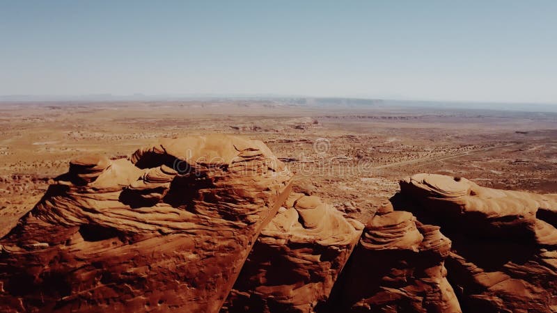 Bourdon se levant au-dessus des falaises massives en vallée de monuments en Arizona indiquant les vastes espaces ouverts sans fin