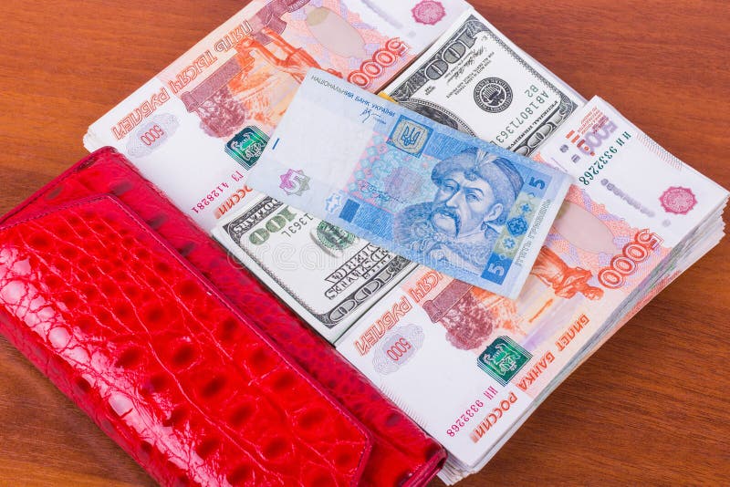 Bourse rouge, bouchons d'argent et hryvnia 5 sur le fond en bois photo stock Bourse rouge, bouchons d'argent et hryvnia 5 sur le fond en bois photo stock