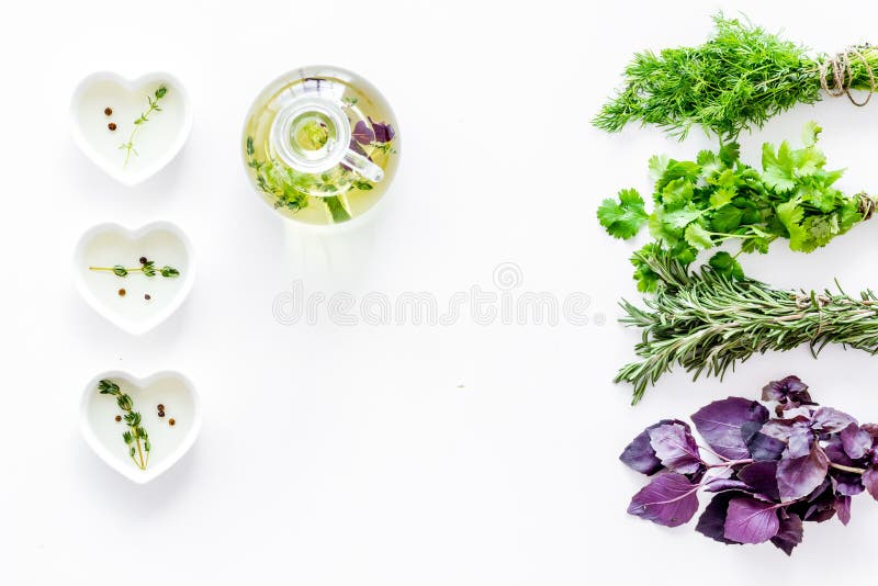 Bouteille avec de l'huile organique avec des ingrédients d'herbes sur la maquette blanche de vue supérieure de fond photos stock Bouteille avec de l'huile organique avec des ingrédients d'herbes sur la maquette blanche de vue supérieure de fond photos stock