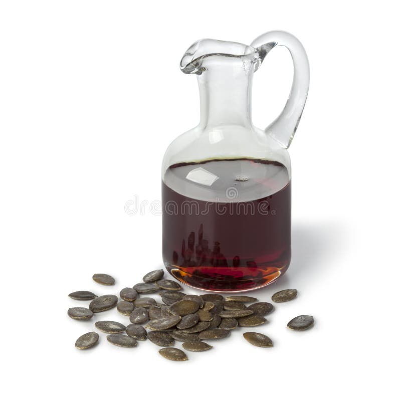 Bouteille avec le pétrole de graine de citrouille et les graines rôties photographie stock libre de droits Bouteille avec le pétrole de graine de citrouille et les graines rôties photographie stock libre de droits