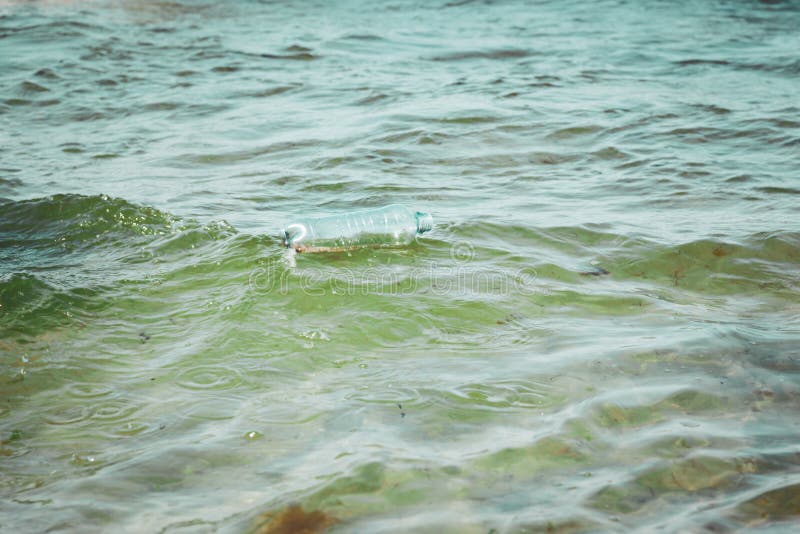 Bouteille en plastique dans l'eau d'océan, salissant l'image de concept de mer photos stock Bouteille en plastique dans l'eau d'océan, salissant l'image de concept de mer photos stock