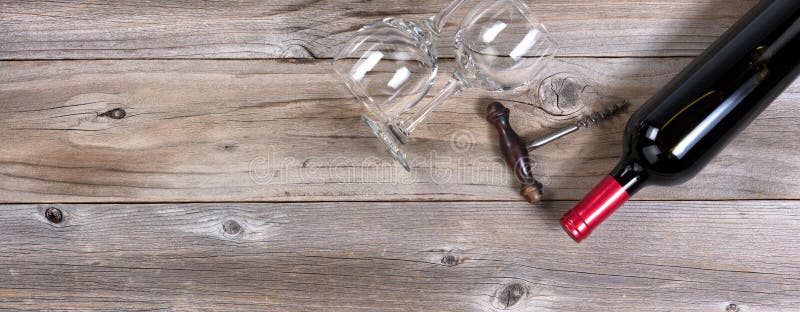 Bouteille Unopen de vin rouge et de verres à boire propres sur W rustique image stock Bouteille Unopen de vin rouge et de verres à boire propres sur W rustique image stock