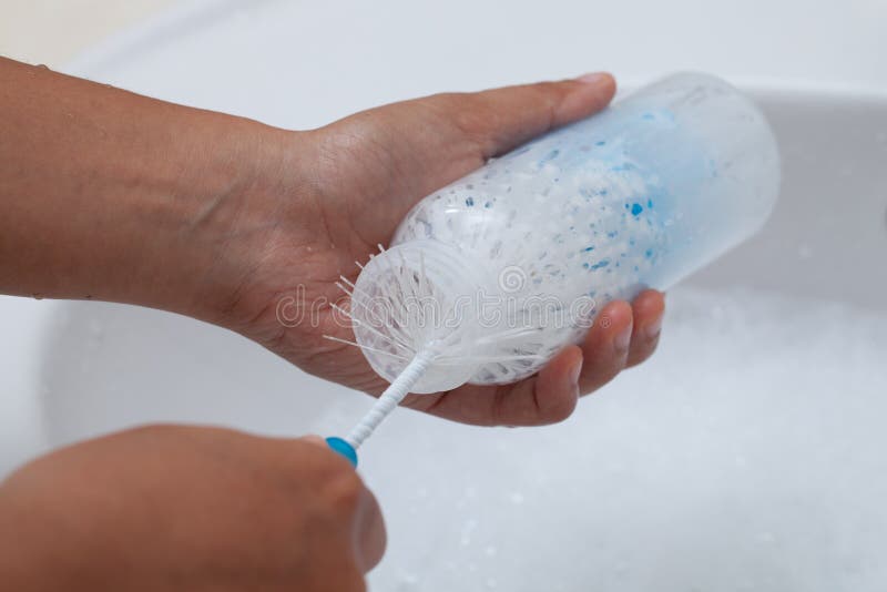 Mère lavant le biberon de bébé image libre de droits