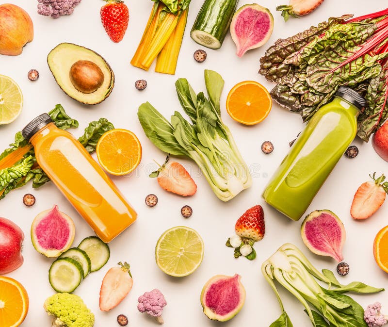 Bouteilles vertes et jaunes de smoothie avec les ingrédients organiques de fruits et légumes : chou frisé, avocat, concombre, ora photo libre de droits Bouteilles vertes et jaunes de smoothie avec les ingrédients organiques de fruits et légumes : chou frisé, avocat, concombre, ora photo libre de droits