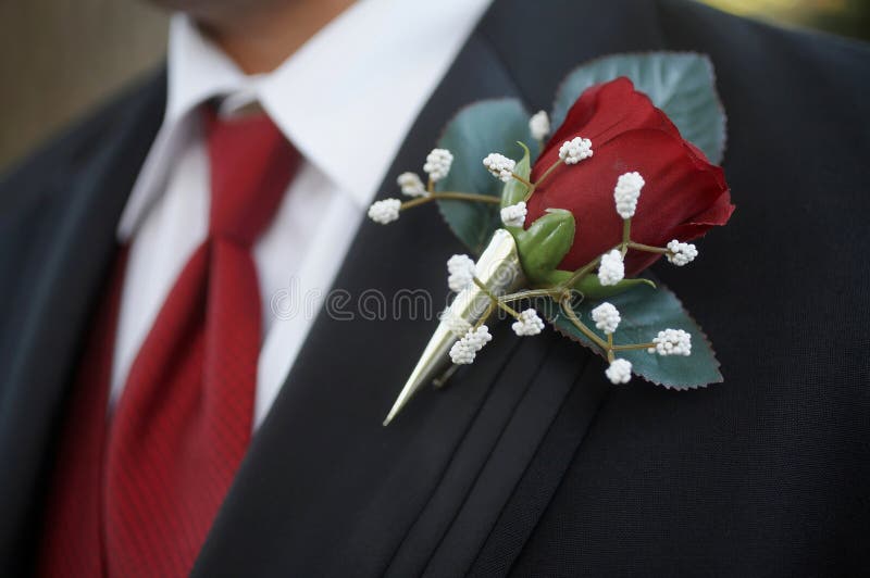 Classic red rose wedding boutonniere on suit of groom