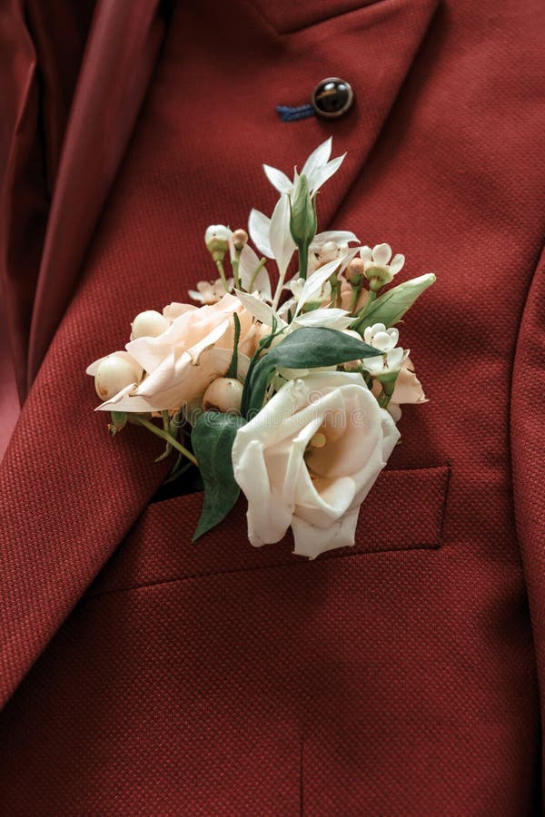 Groom`s boutonniere on a maroon suit. Groom`s boutonniere on a maroon suit