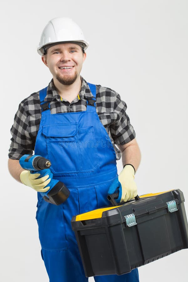 Bouw, de bouw en arbeidersconcept - Knappe toolbox en de schroevedraaier van de bouwersholding op witte achtergrond royalty-vrije stock afbeeldingen Bouw, de bouw en arbeidersconcept - Knappe toolbox en de schroevedraaier van de bouwersholding op witte achtergrond royalty-vrije stock afbeeldingen