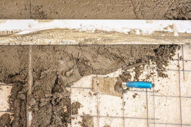 Bouwersarbeider het pleisteren beton bij vloer van huisbouw royalty-vrije stock fotografie Bouwersarbeider het pleisteren beton bij vloer van huisbouw royalty-vrije stock fotografie