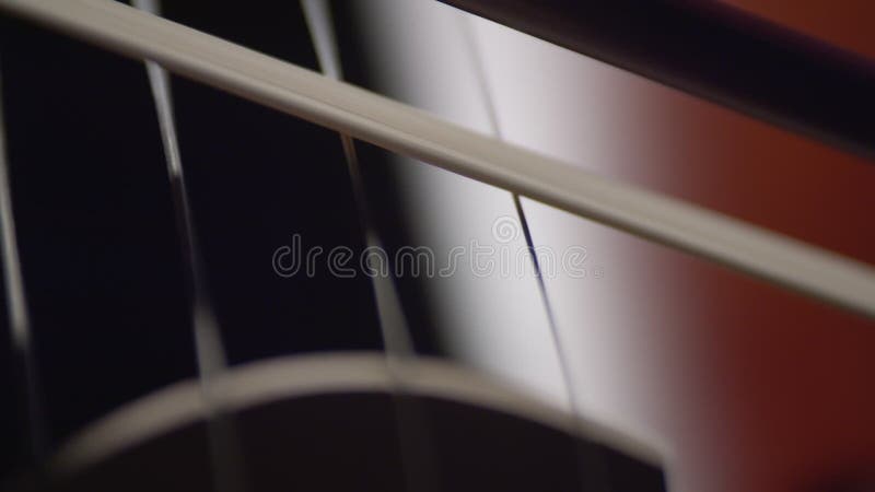 Bow plays on strings of cello reproducing classical music, closeup. Musician plays bow on strings of musical instrument stock video