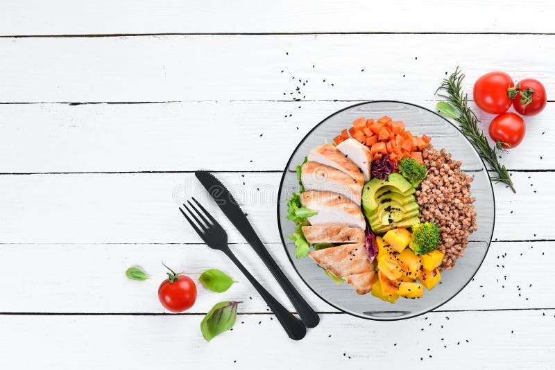 Bowl Buddha. Buckwheat, pumpkin, chicken fillet, avocado, carrots. On a white wooden background. stock image Bowl Buddha. Buckwheat, pumpkin, chicken fillet, avocado, carrots. On a white wooden background. stock image