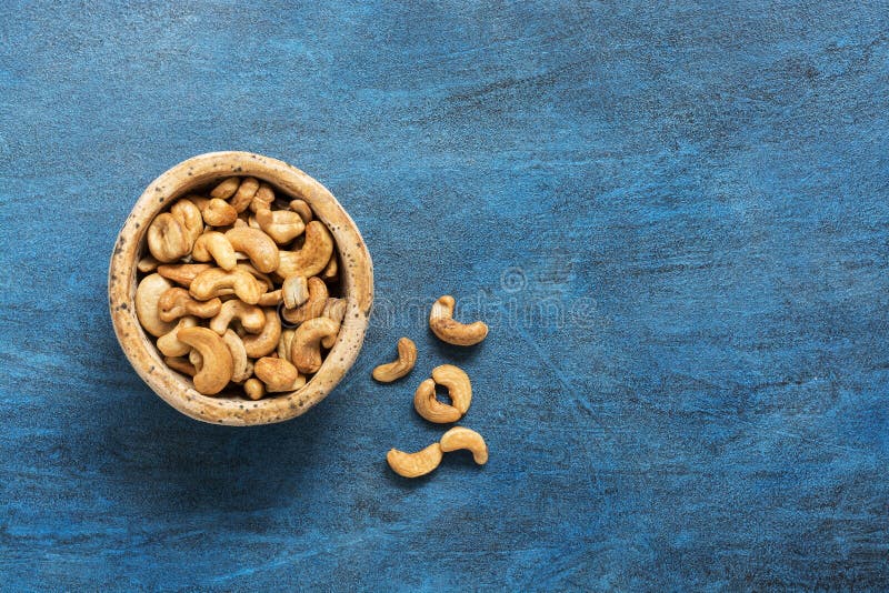 Bowl with cashew nuts on a blue background. View from above. Copy space. royalty free stock photos Bowl with cashew nuts on a blue background. View from above. Copy space. royalty free stock photos