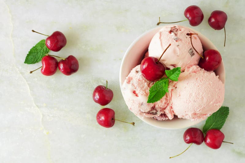 Bowl of cherry chocolate ice cream, above view over white marble