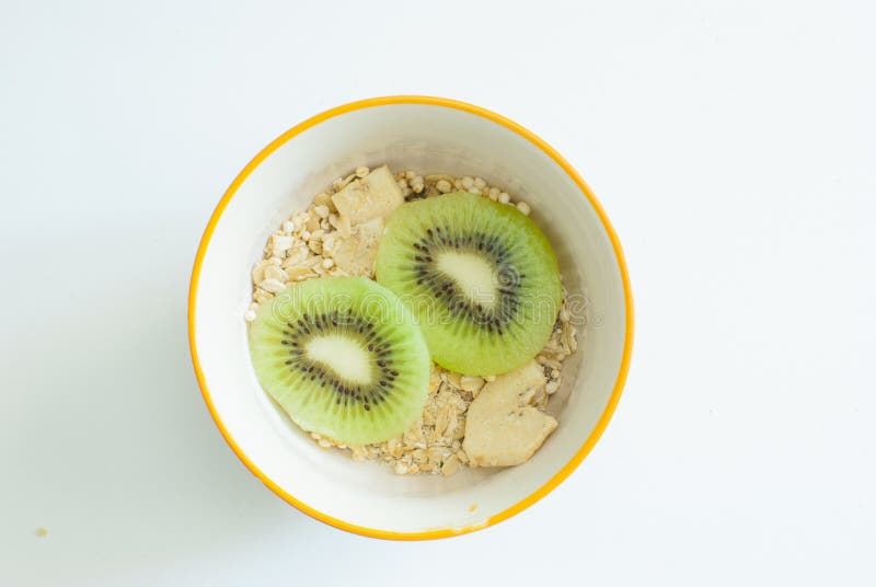 Bowl di muesli con frutta fresca Dall'alto, la ciotola di ceramica bianca di muesli con fette di kiwi freschi su bianco fotografie stock