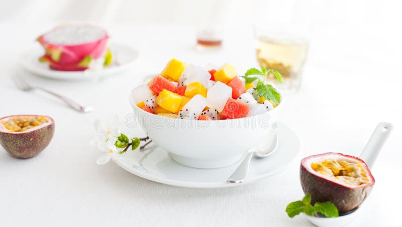 Bowl of fresh exotic fruit salad on white summer background Healthy breakfast stock photos Bowl of fresh exotic fruit salad on white summer background Healthy breakfast stock photos