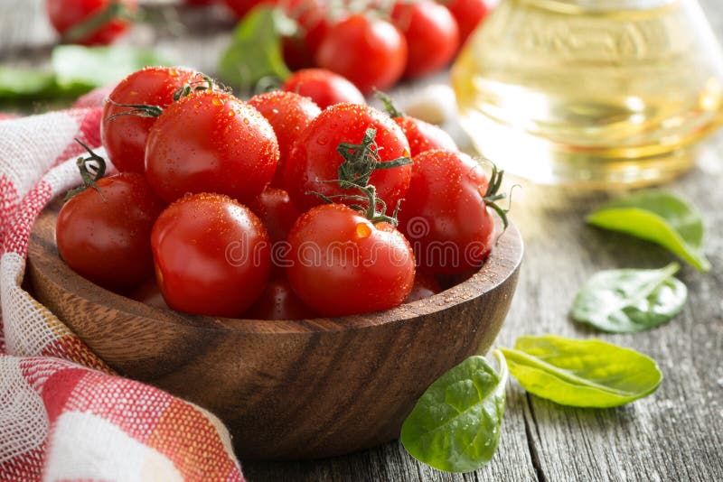 bowl with fresh tomatoes, spinach and olive oil, close-up