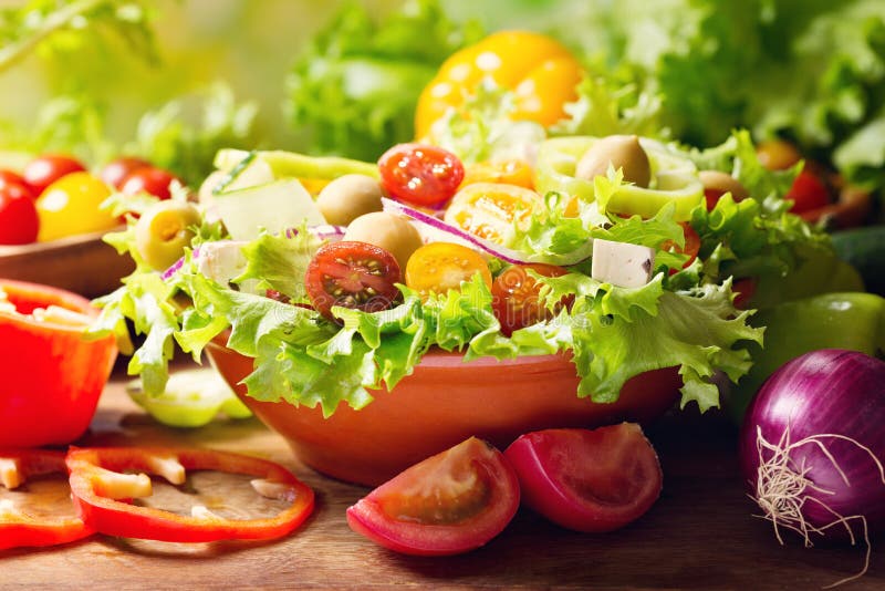 Bowl of fresh vegetable salad on wooden table