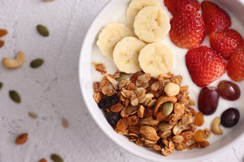 Bowl of Granola Cereal with Yogurt and Berries Isolated on White