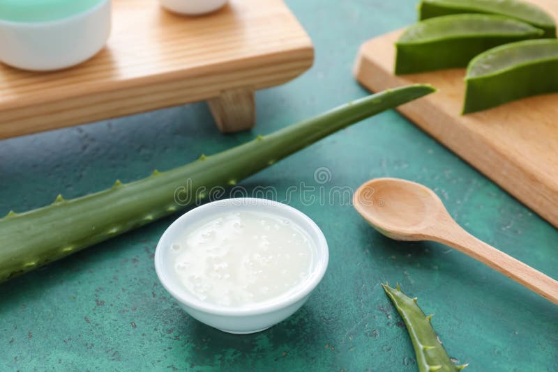 Bowl with healing cream and aloe on color table stock photos Bowl with healing cream and aloe on color table stock photos
