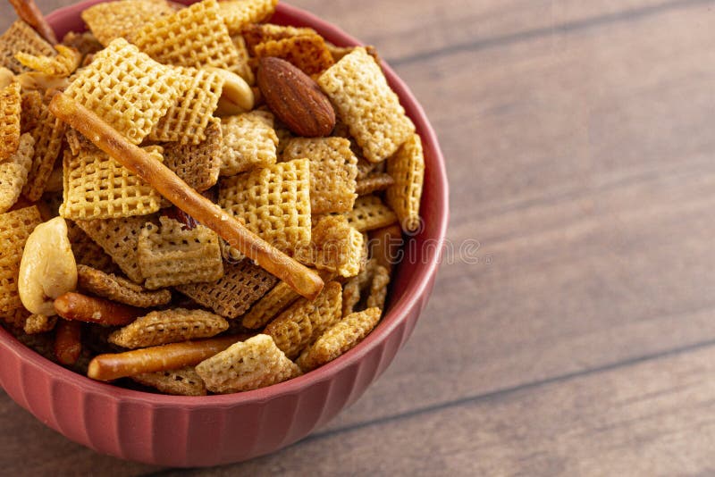 Bowl of Homemade Cereal Nut and Prezel Trail Mix on a Wooden Table