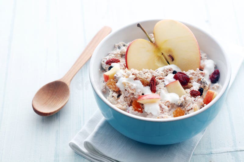 Bowl of muesli, apple, fruit, nuts and milk