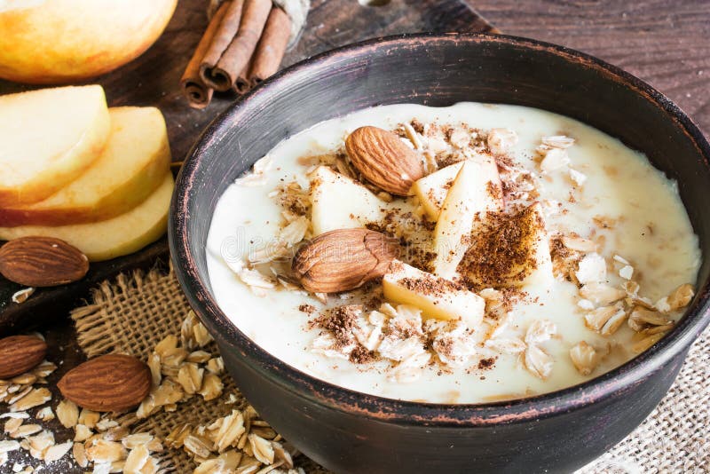 Bowl of oatmeal porridge with apple, cinnamon and almonds