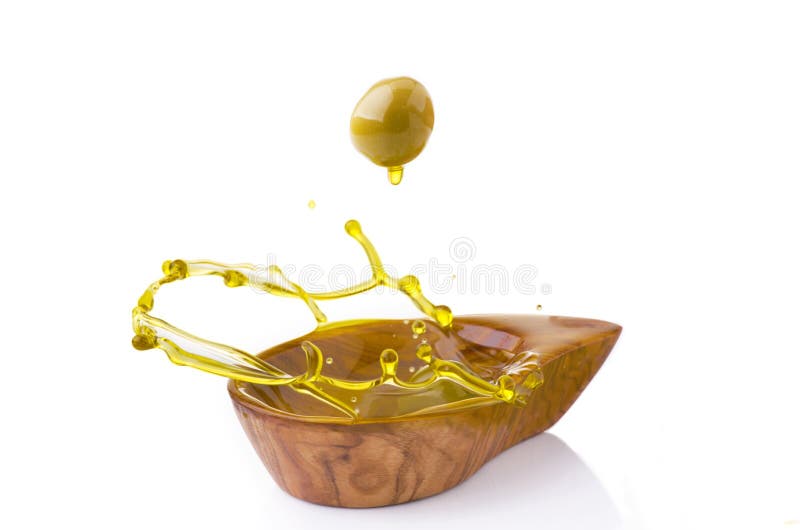 A bowl with oil splashing under a fall of green olive