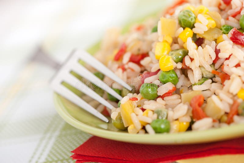 Bowl of rice with peas and red peppers stock photography