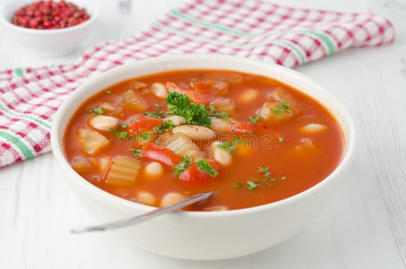 Bowl of roasted tomato soup with beans, celery and bell pepper