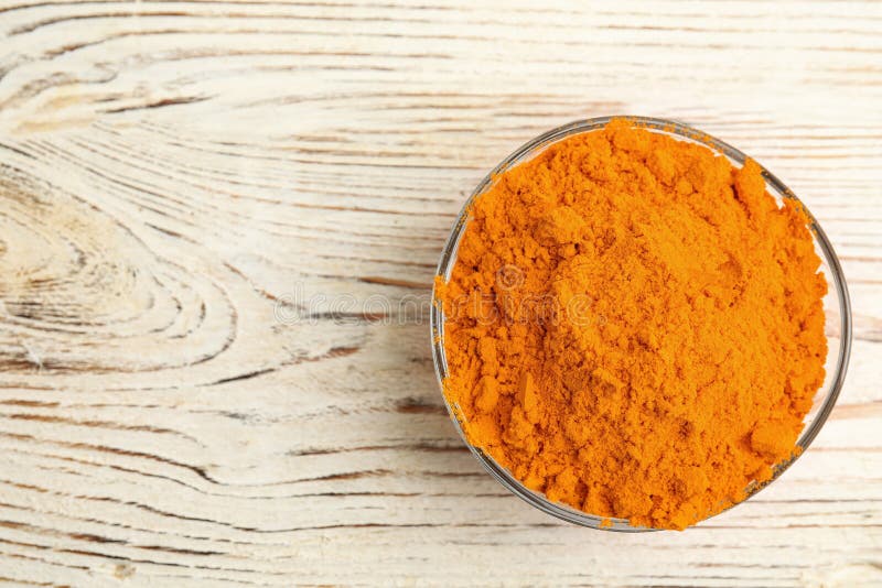 Bowl with saffron powder on white wooden table, top view. Space for text stock photos