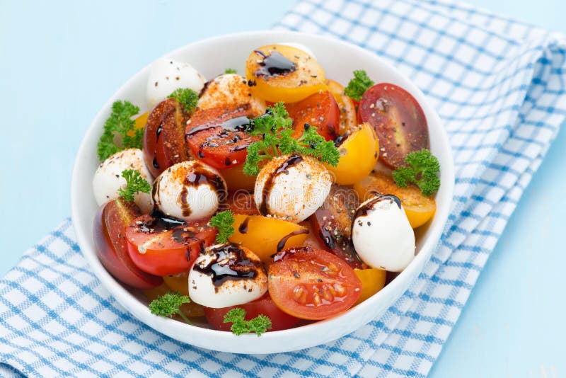 Bowl of salad with mozzarella, balsamic sauce and tomatoes
