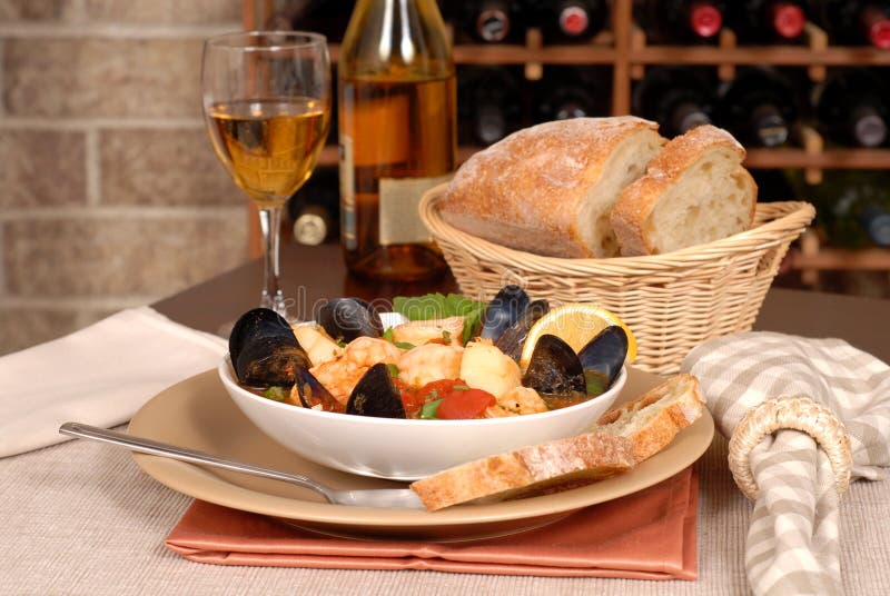 Bowl of seafood soup with wine and rustic bread