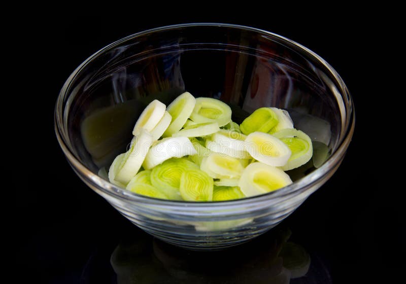 Bowl with sliced leek on black royalty free stock image