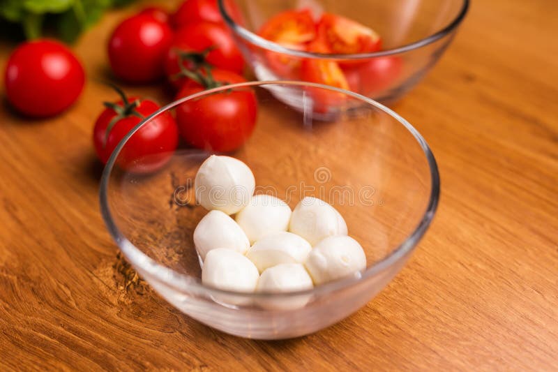 Bowl of Small Mozzarella Balls with Tomatoes in Kitchen Stock Image