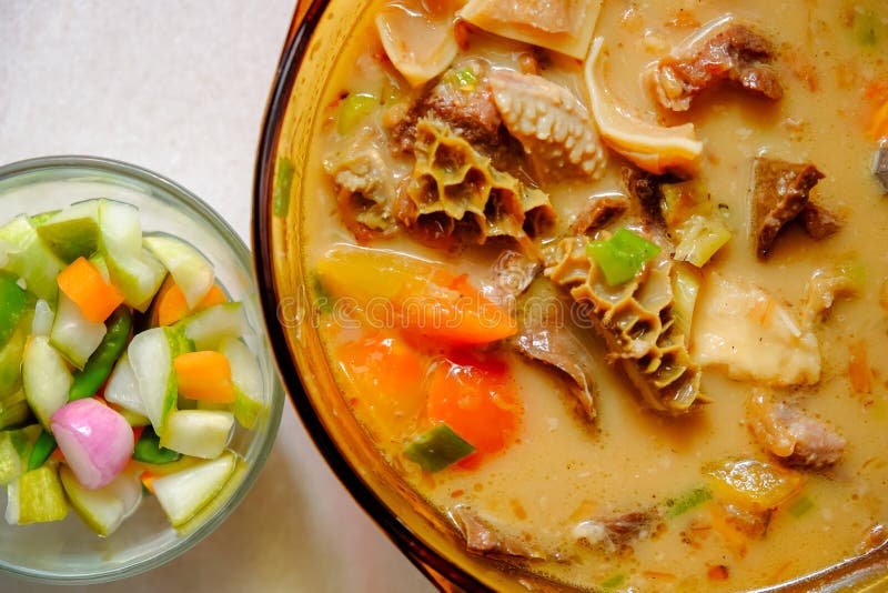 A bowl of Soto Betawi, Indonesian native traditional soup made of beef or beef offal cooked in coconut milk broth with pickles