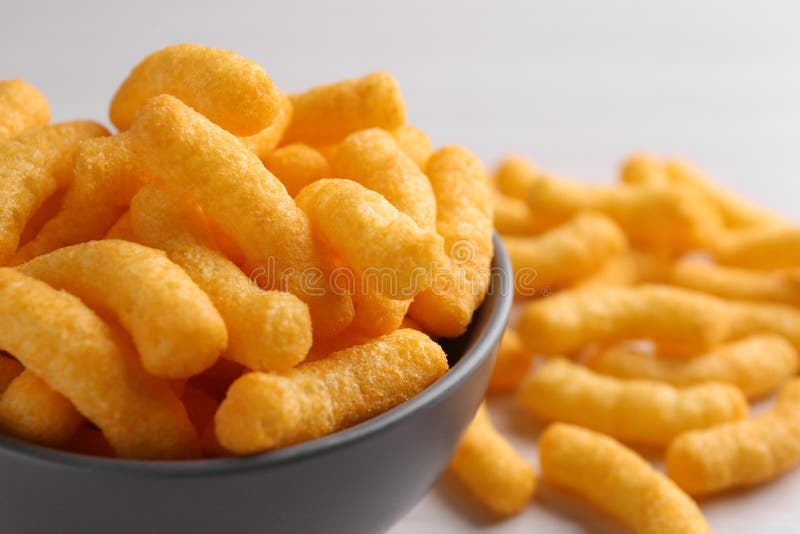 Bowl of Tasty Cheesy Corn Puffs, Closeup. Space for Text Stock Photo