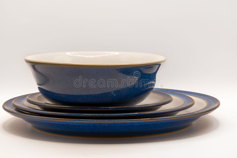 Bowl and Three Crockery Plates of White and Blue Colors Stock Photo