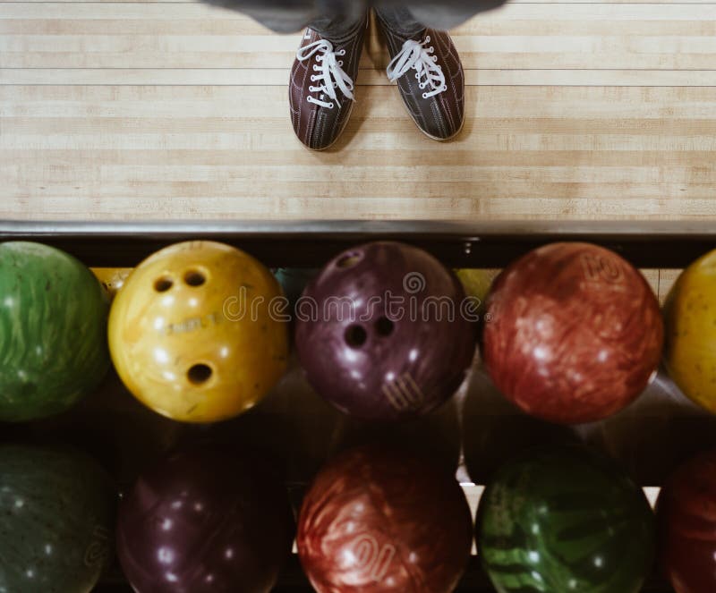 Bowling Shoes with Multicolored Bowling Balls POV Top View Stock Photo