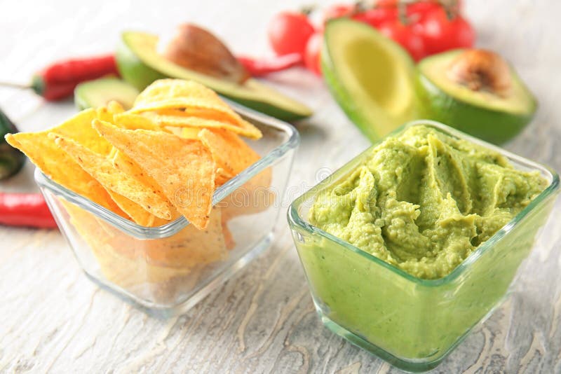 Bowls with delicious guacamole and nachos on table royalty free stock image