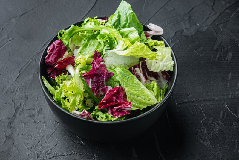 Bowls with Mixed Shredded Salad Lettuce Leaves, on Black Background