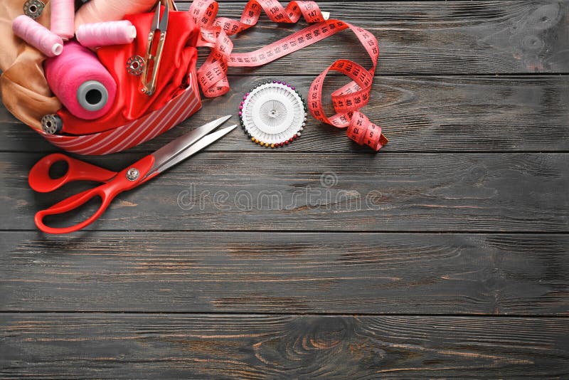 Box with Color Threads and Sewing Accessories on Wooden Background