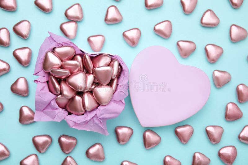 Box and Delicious Heart Shaped Candies on Light Blue Background, Flat