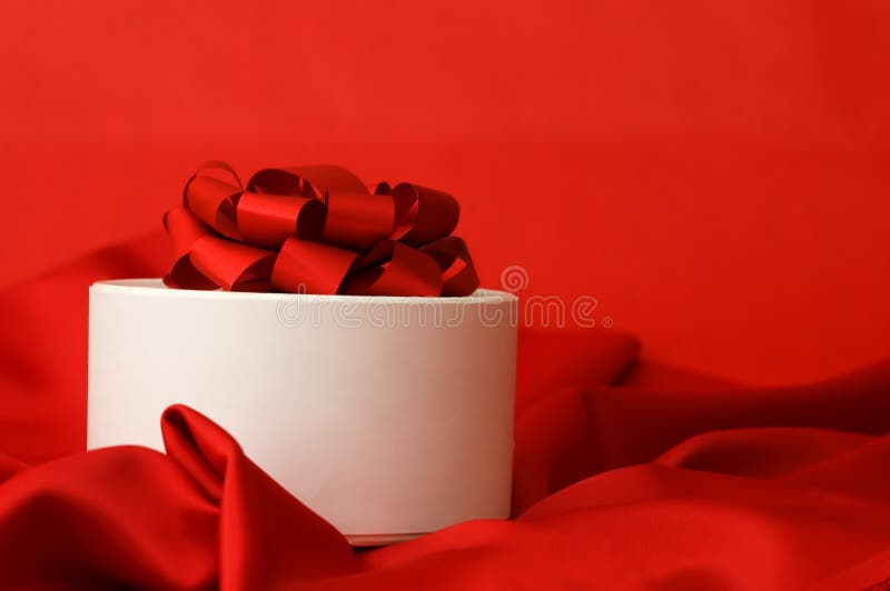 Box with a gift on a red fabric