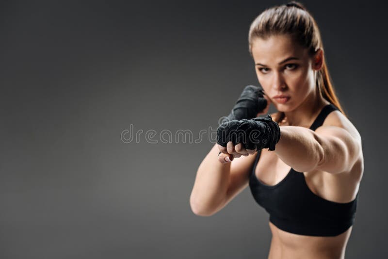 Boxe puissante de femme sur un fond gris photo stock Boxe puissante de femme sur un fond gris photo stock