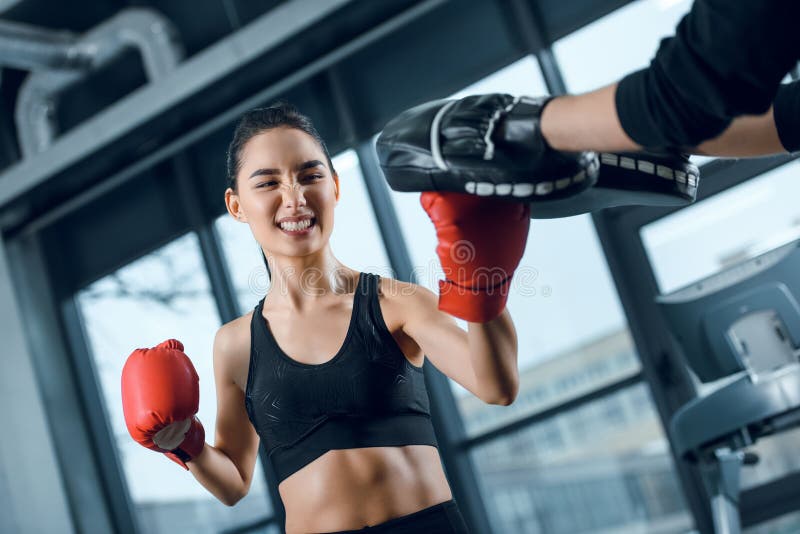 Boxeador de sexo femenino joven expresivo que ejercita con el instructor fotografía de archivo libre de regalías